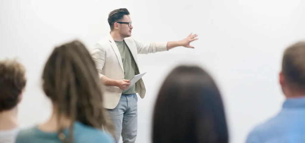 Ein Mann hält eine Präsentation vor einer Gruppe von Menschen.